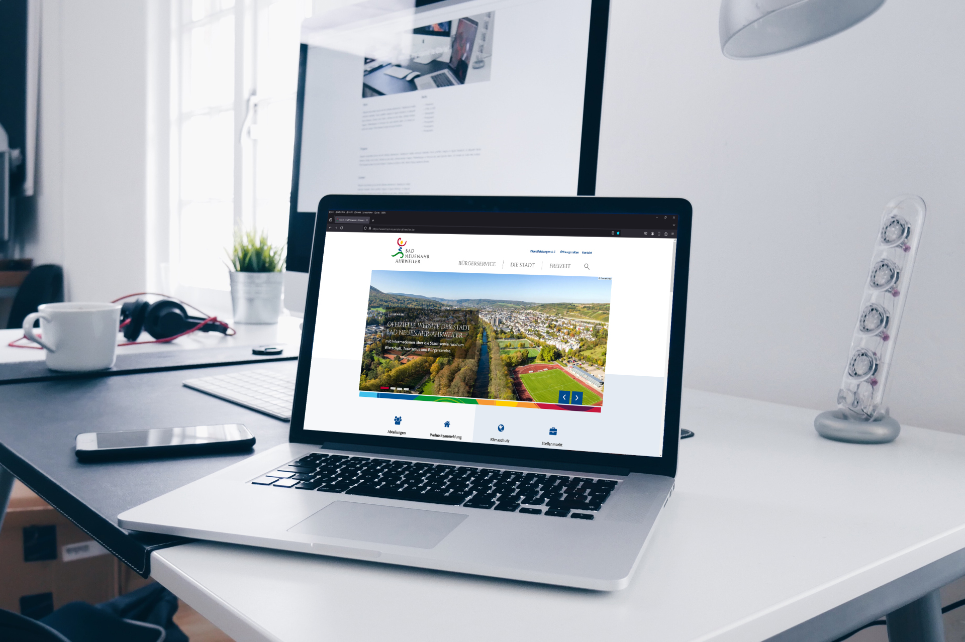 Laptop mit neuem Stadtportal auf Schreibtisch