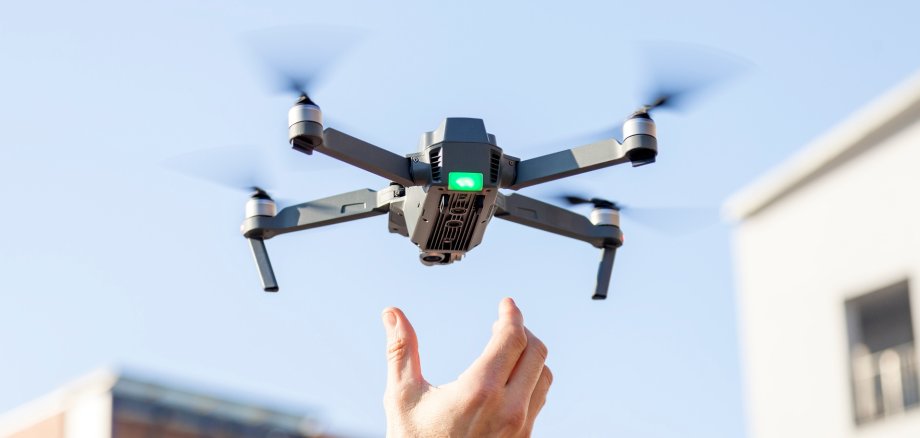 black drone lands in the hands of technician