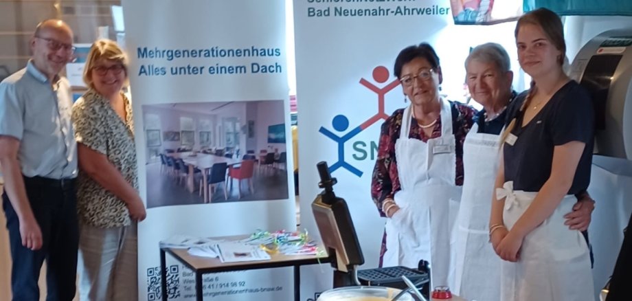 Mit „Spitzenschürzen“ und viel Engagement dabei: Ehrenamtliche und eine Bundesfreiwillige des HdF/MGH sowie das SeniorenNetzWerk sorgten beim Lesesommer-Abschluss für frische Waffeln und strahlende Gesichter. Abgebildet v.l.: Pfarrer Friedemann Bach, Marion Surrey, Theresia Weber, Ingrid Mecklenburg und Carolina Gottschalt. Mit „Spitzenschürzen“ und viel Engagement dabei: Ehrenamtliche und eine Bundesfreiwillige des HdF/MGH sowie das SeniorenNetzWerk sorgten beim Lesesommer-Abschluss für frische Waffeln und strahlende Gesichter. Abgebildet v.l.: Pfarrer Friedemann Bach, Marion Surrey, Theresia Weber, Ingrid Mecklenburg und Carolina Gottschalt.