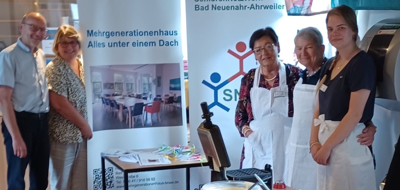 Mit „Spitzenschürzen“ und viel Engagement dabei: Ehrenamtliche und eine Bundesfreiwillige des HdF/MGH sowie das SeniorenNetzWerk sorgten beim Lesesommer-Abschluss für frische Waffeln und strahlende Gesichter. Abgebildet v.l.: Pfarrer Friedemann Bach, Marion Surrey, Theresia Weber, Ingrid Mecklenburg und Carolina Gottschalt.