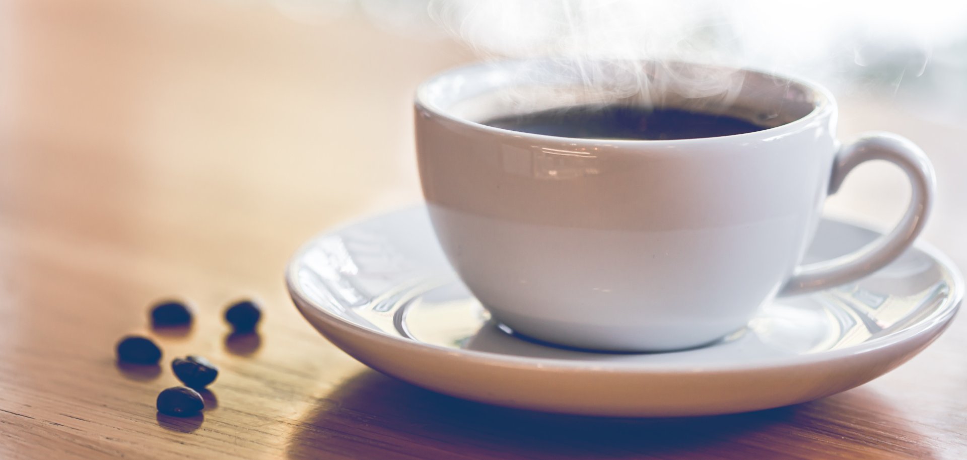Hot coffee with smoke on the table in coffee shop