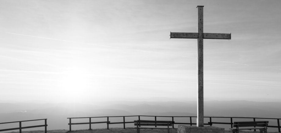 Kreuz auf dem Gipfel des Monte Serrasanta (Umbrien, Italien), mit tief am Horizont stehender Sonne.