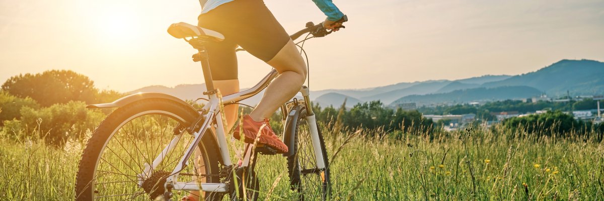 Radfahrerin mit Helm beim Radfahren im Freien an einem sonnigen Tag