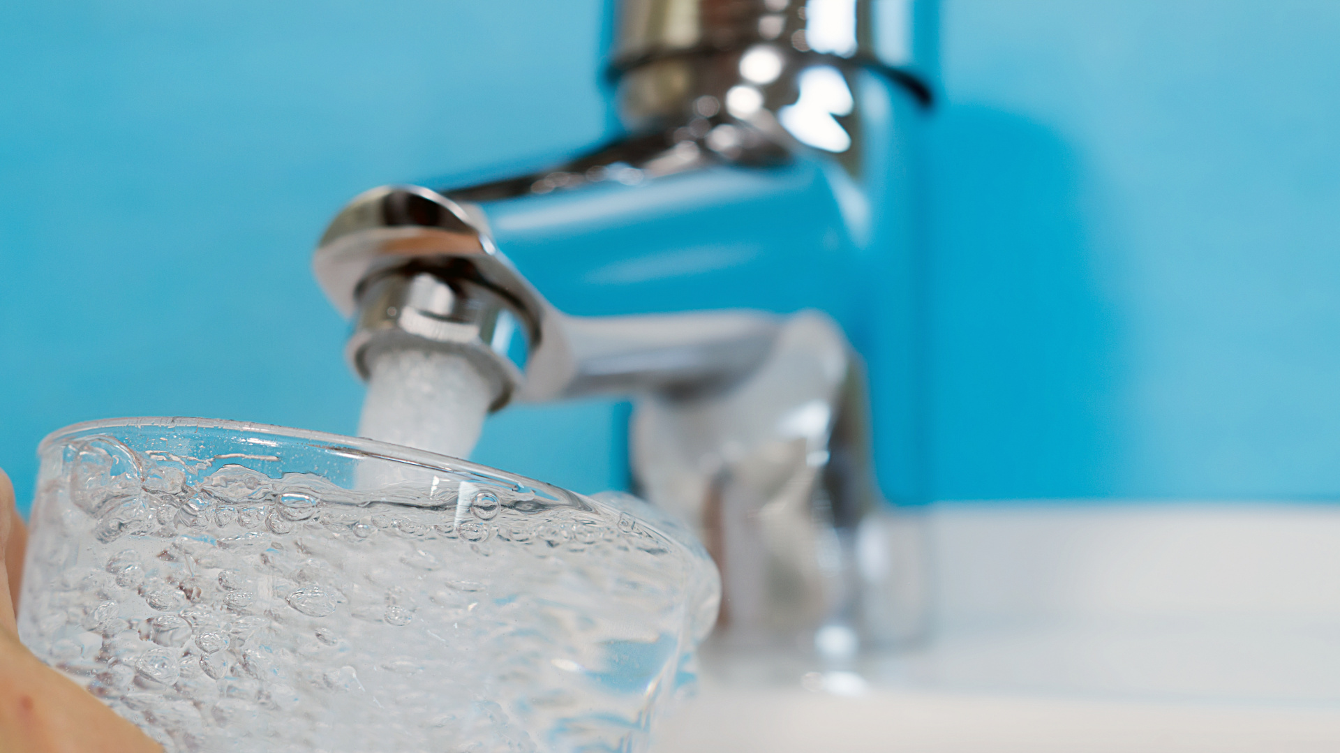 Trinkwasser läuft in ein Glas unter einem Wasserhahn